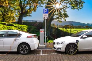 A profile view of two electric cars charging.