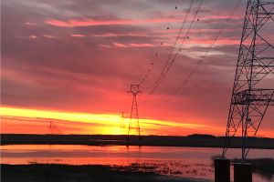 Sunset photo of high voltage transmission lines.